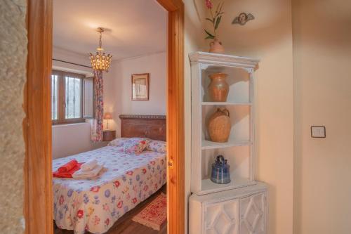 ein Schlafzimmer mit einem Bett und einem Spiegel in der Unterkunft El Casuco in Santa María de Redondo