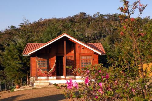 una pequeña casa de madera en la cima de una montaña en Bosque dos Beija-Flores Pousada e Spa, en São Thomé das Letras