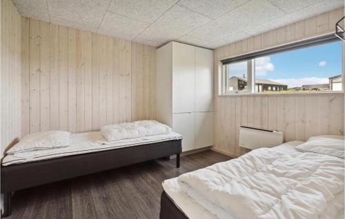 a bedroom with two beds and a window at Holiday Home Haderslev With Sea View 12 in Kelstrup Strand