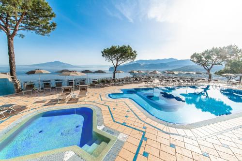 a pool with chairs and umbrellas on a resort at Grand Hotel President in Sorrento