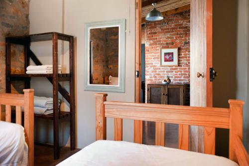 a bedroom with a bed and a brick wall at Dalmore Guest Farm in Bergville