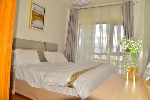 Un dormitorio con una cama grande con ventana. en Casamia luxury 2, en Nairobi
