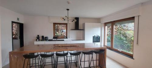 a kitchen with a large island with bar stools at D'Hestia - Gîte avec vue imprenable sur Huy in Huy