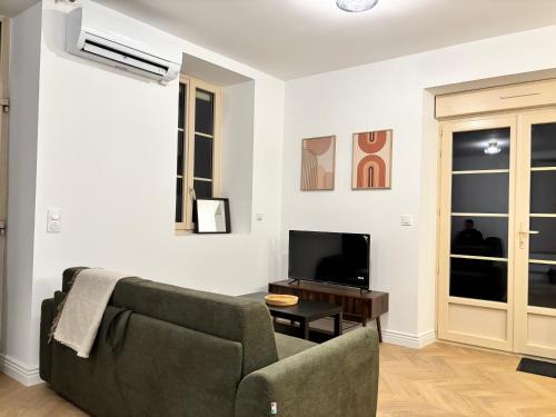un salon avec un canapé et une télévision dans l'établissement Maison de ville 4 personnes avec jardin, à Bonnétable