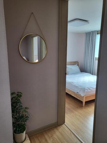 a mirror on a wall next to a bedroom at Greece - Foreigners only in Gyeongju