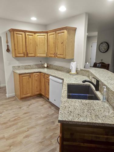 an empty kitchen with a sink and wooden cabinets at Hermosa Haven home in Montrose