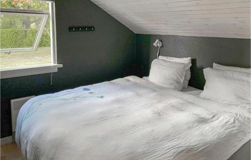 a bedroom with a white bed with a green wall at Three-Bedroom Holiday Home In Stubbekobing in Stubbekøbing