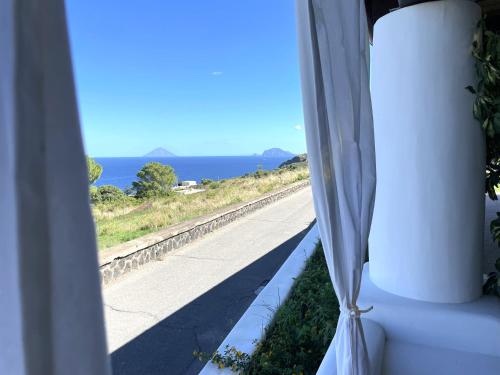 a window with a view of a road and the ocean at Case a Malfa - Alba & Rosina, Isola Salina in Malfa
