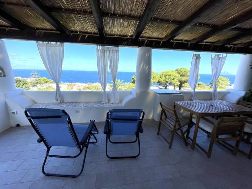 a room with a table and chairs and the ocean at Case a Malfa - Alba & Rosina, Isola Salina in Malfa