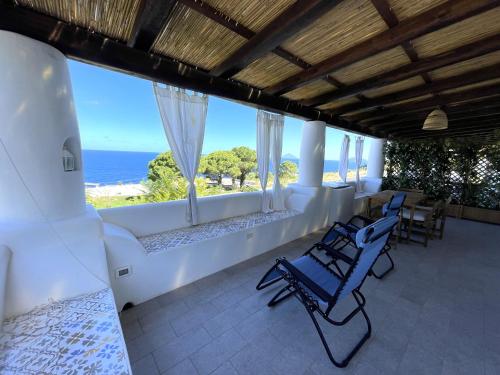 a porch with chairs and a view of the ocean at Case a Malfa - Alba & Rosina, Isola Salina in Malfa