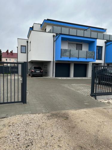 a house with a car parked in front of it at Swiss Star Apartment in Mosonmagyaróvár