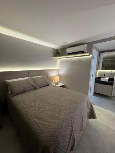 Flat piscina borda infinita a 50m do mar - 214 في جواو بيسوا: غرفة نوم بها سرير كبير ومرآة