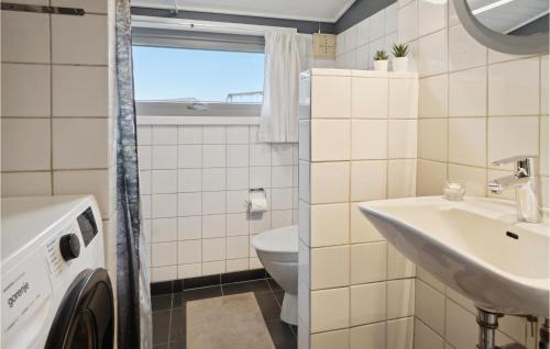 a bathroom with a washing machine and a sink at 2 Bedroom Stunning Home In Rømø in Lakolk