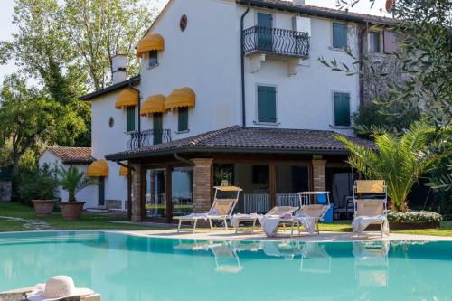 a house with a swimming pool in front of a house at Apartment Villa Kennedy - Bob in Sirmione