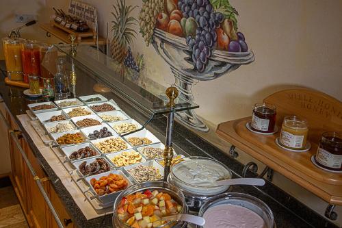Un buffet lleno de diferentes tipos de comida en un mostrador. en Berglandhotel Untertheimerhof, en Villandro