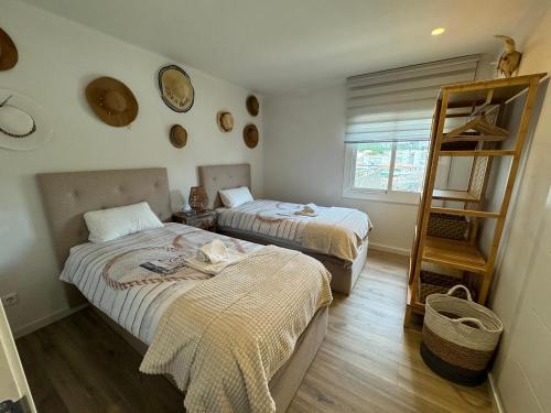 1 dormitorio con 2 camas, estante y ventana en Perla del Mar, en Platja d'Aro
