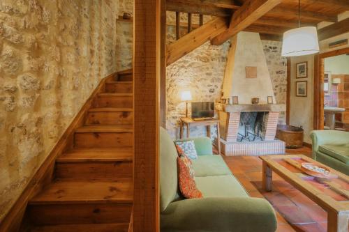 a living room with a staircase and a fireplace at Capellan in Olmos de Ojeda
