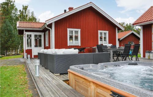 a hot tub on a deck next to a red house at Stunning Home In Karlstad With Sauna in Karlstad