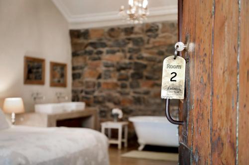 a room with a bed and a bathroom with a tub at Dalmore Guest Farm in Bergville