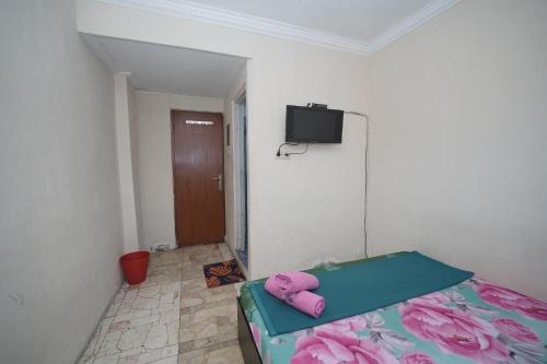 a bedroom with a bed and a flat screen tv at WABS Syariah in Bandung