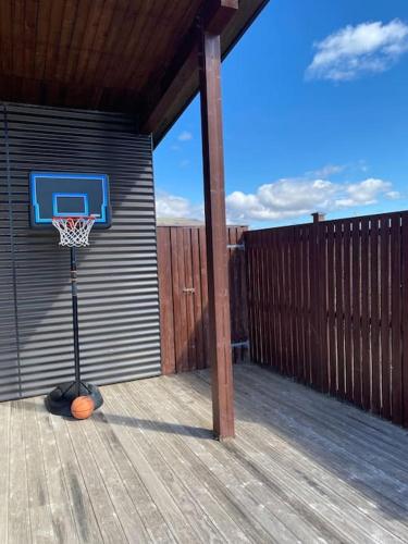 a basketball hoop on a deck with a fence at Prime Location-Golden Circle 3 Bedrooms in Selfoss