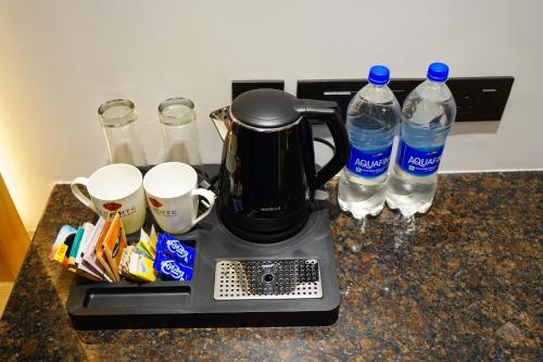 a coffee maker and two bottles of water on a counter at WelcomHeritage Natraj, Mcleod Ganj in McLeod Ganj
