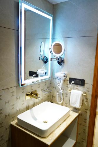 a bathroom with a sink and a mirror at WelcomHeritage Natraj, Mcleod Ganj in McLeod Ganj