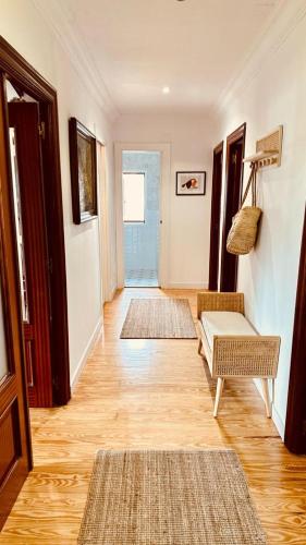a hallway with two rugs and two chairs and a door at El Capricho de Comillas in Comillas
