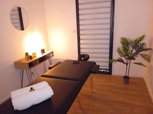 un salon avec un canapé et une plante en pot dans l'établissement Le Paradis Secret Plage et Balneo, à Gouville-sur-Mer