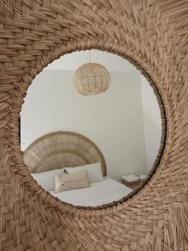 - un miroir reflétant un lit dans une chambre dans l'établissement Le Paradis Secret Plage et Balneo, à Gouville-sur-Mer