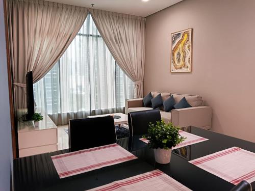 a living room with two tables and a couch at Soho Suites KLCC by Minsha in Kuala Lumpur