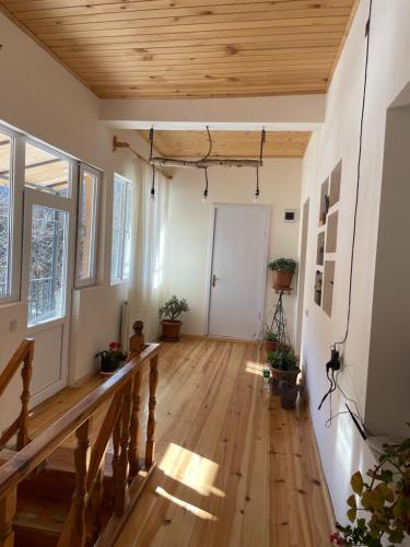 an empty room with a wooden floor and a hallway at Mamuka Chartolani Guesthouse in Mestia