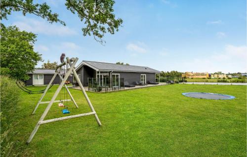 a person on a ladder in a yard at Stunning Home In Væggerløse With Wifi in Marielyst