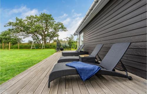 two chairs and a table on a wooden deck at Stunning Home In Væggerløse With Wifi in Marielyst