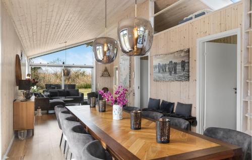 a dining room with a large wooden table and chairs at Stunning Home In Væggerløse With Wifi in Marielyst
