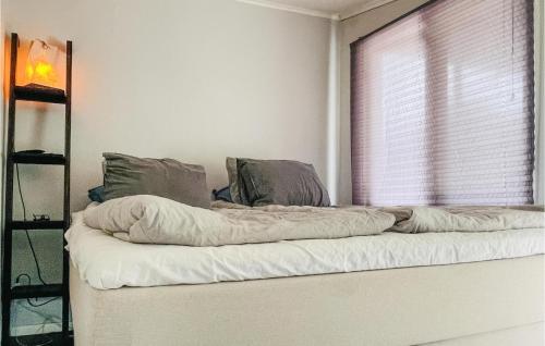a bed with a blanket on it in a room with a window at 1 Bedroom Awesome Home In Ronneby in Ronneby