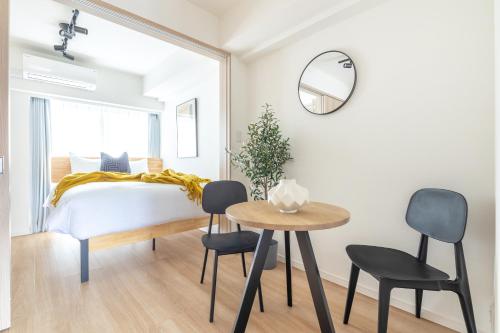 a bedroom with a bed and a table and chairs at Dash Living Asakusa East in Tokyo