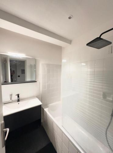 une salle de bain blanche avec une baignoire et un lavabo dans l'établissement Iris, à Graulhet