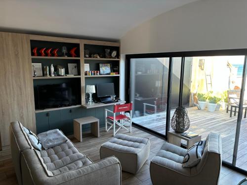 un salon avec deux chaises et une télévision dans l'établissement Maison les pieds dans l'eau, à Lumio