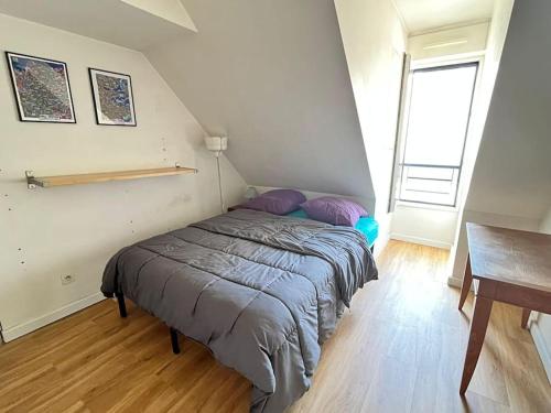 Cette chambre comprend un lit avec des oreillers violets et un bureau. dans l'établissement 3 chambres terrasse et parking gratuit, à Paris