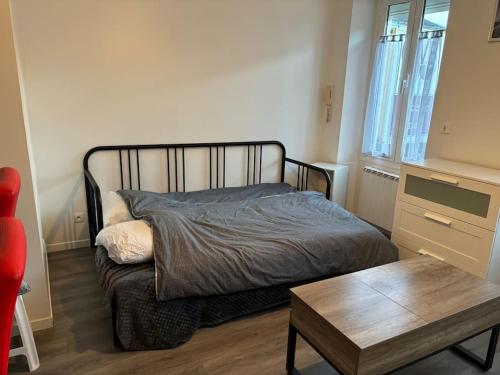 - une chambre avec un lit et une table basse dans l'établissement Plein centre, à Malesherbes