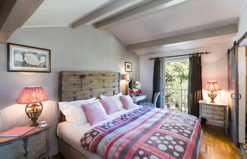 une chambre avec un grand lit et une fenêtre dans l'établissement Maison de Gordes, à Gordes