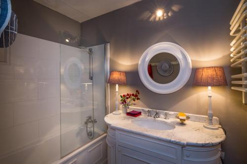 une salle de bain avec un lavabo et une douche avec un miroir dans l'établissement Maison de Gordes, à Gordes