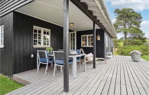 Un patio con una mesa y sillas en una terraza. en Holiday Home Bjerges Toft, en Fanø
