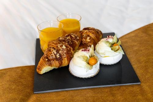 a plate of pastries and two glasses of orange juice at F-Apartments - City Center with Fireplace, Contactless in Tartu