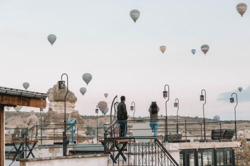 a group of people looking at hot air balloons at Turan Cappadocia Cave in Goreme