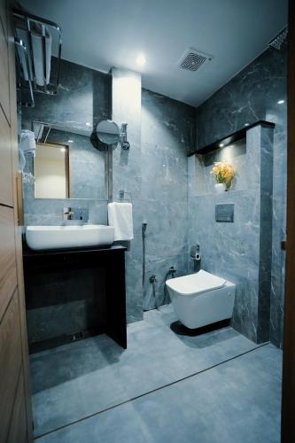 a bathroom with a sink and a toilet at Hotel JK palace in Allahābād