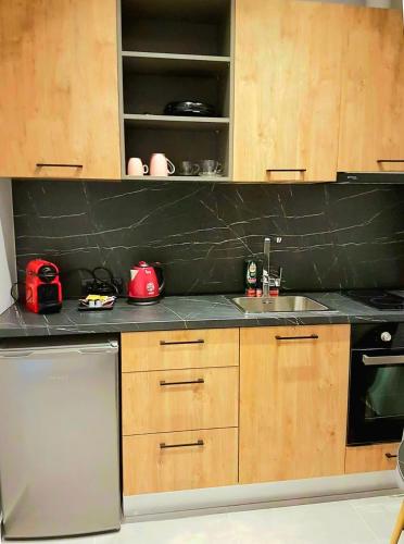 a kitchen with wooden cabinets and a black counter top at K35 Apartments in Preveza
