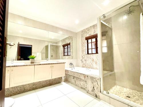 Un baño con ducha, bañera y lavabo. en BB Hers Cheesy, en Midrand