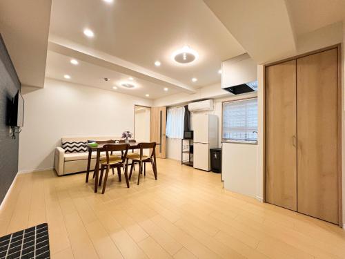 a kitchen and dining room with a table and a couch at RUKA guest house in Osaka